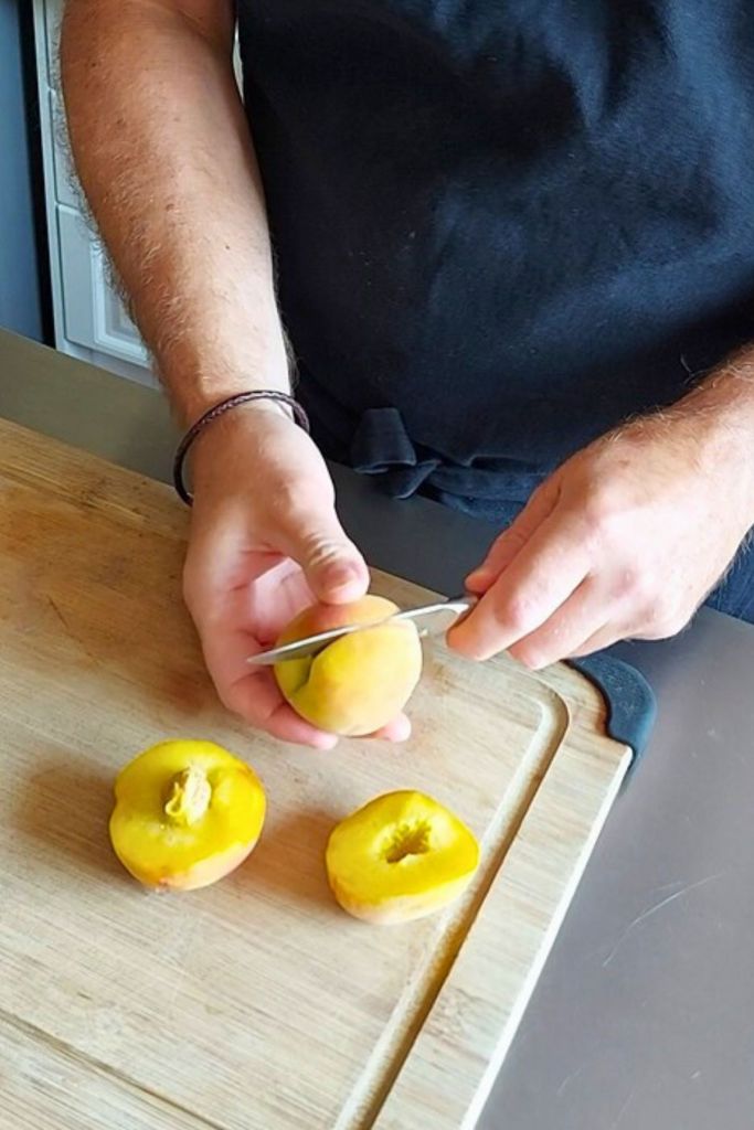 Cutting peach vertical to remove pit.