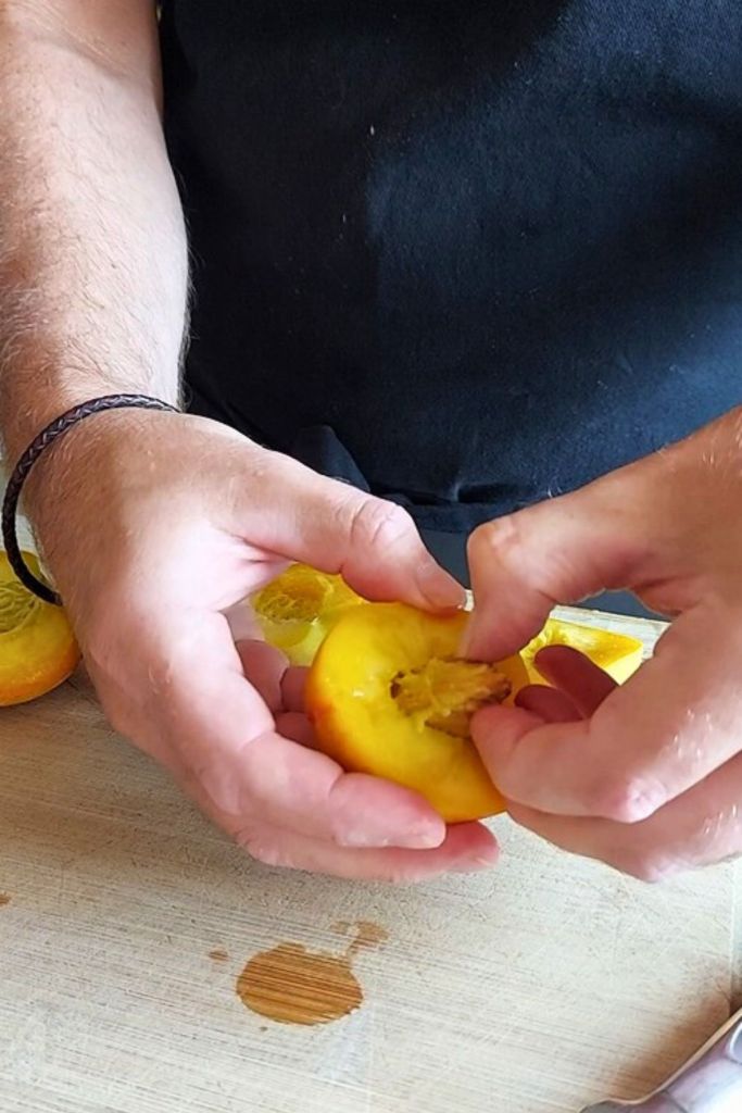 Removing peach pit using hands - after horizontal cut.