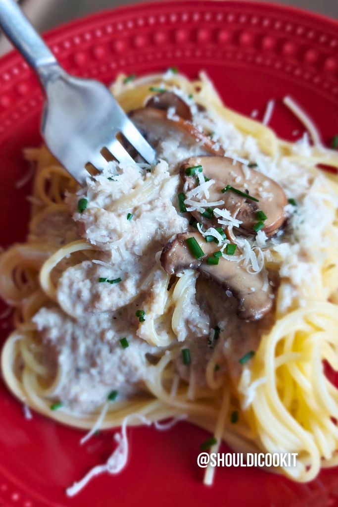 Fork digging into Mushroom wine sauce served over pasta